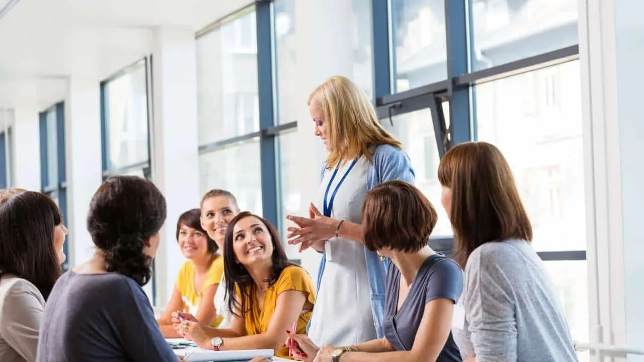 Grupo de mujeres sentadas en una mesa durante una reunión en un entorno de oficina.