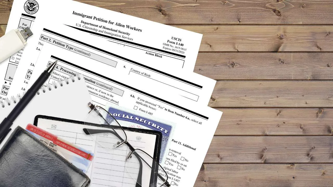 Formulario de solicitud de visa de trabajo junto a una libreta y gafas sobre una mesa de madera.