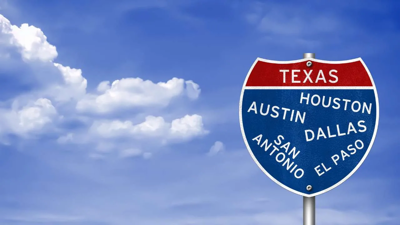 Señal de tráfico azul y roja que indica las ciudades de Texas: Houston, Austin, Dallas, San Antonio y El Paso.
