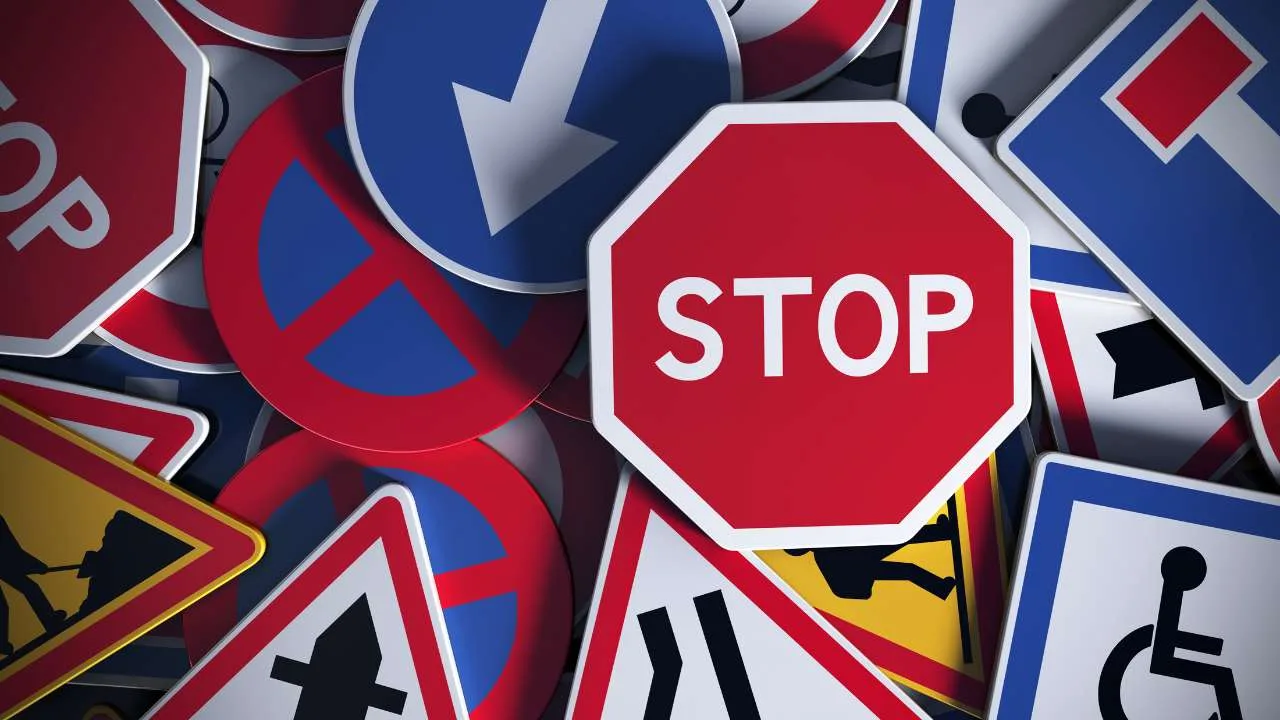 Conjunto de señales de tránsito, incluyendo una señal de alto en primer plano.