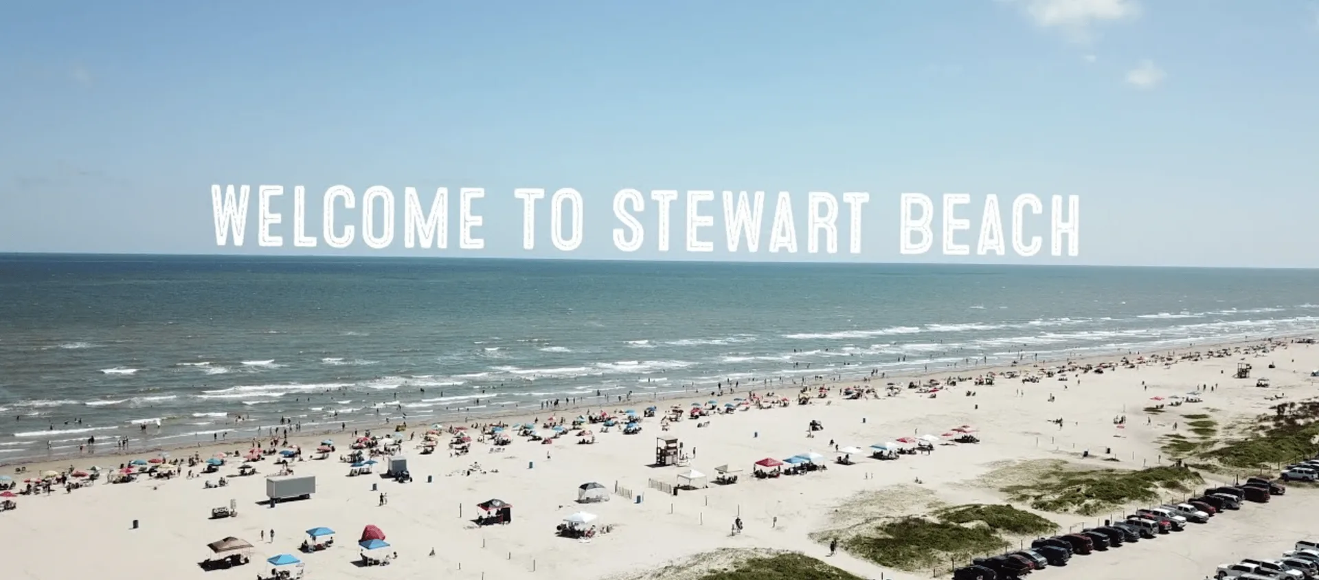 Varias personas de pie en un evento, algunas conversando y otras mirando hacia adelante.