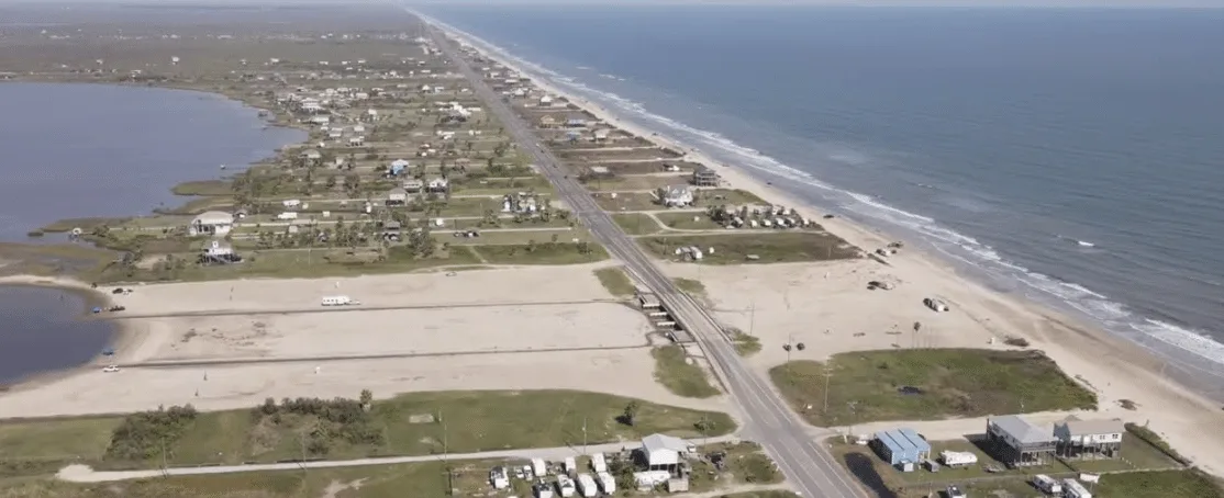 Dos hombres de negocios sonrientes en trajes formales, de pie uno al lado del otro en un entorno interior.