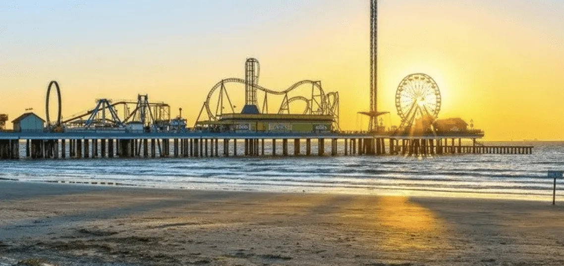 Dentista con barba y sonrisa, vestido con bata blanca y corbata en un consultorio dental.