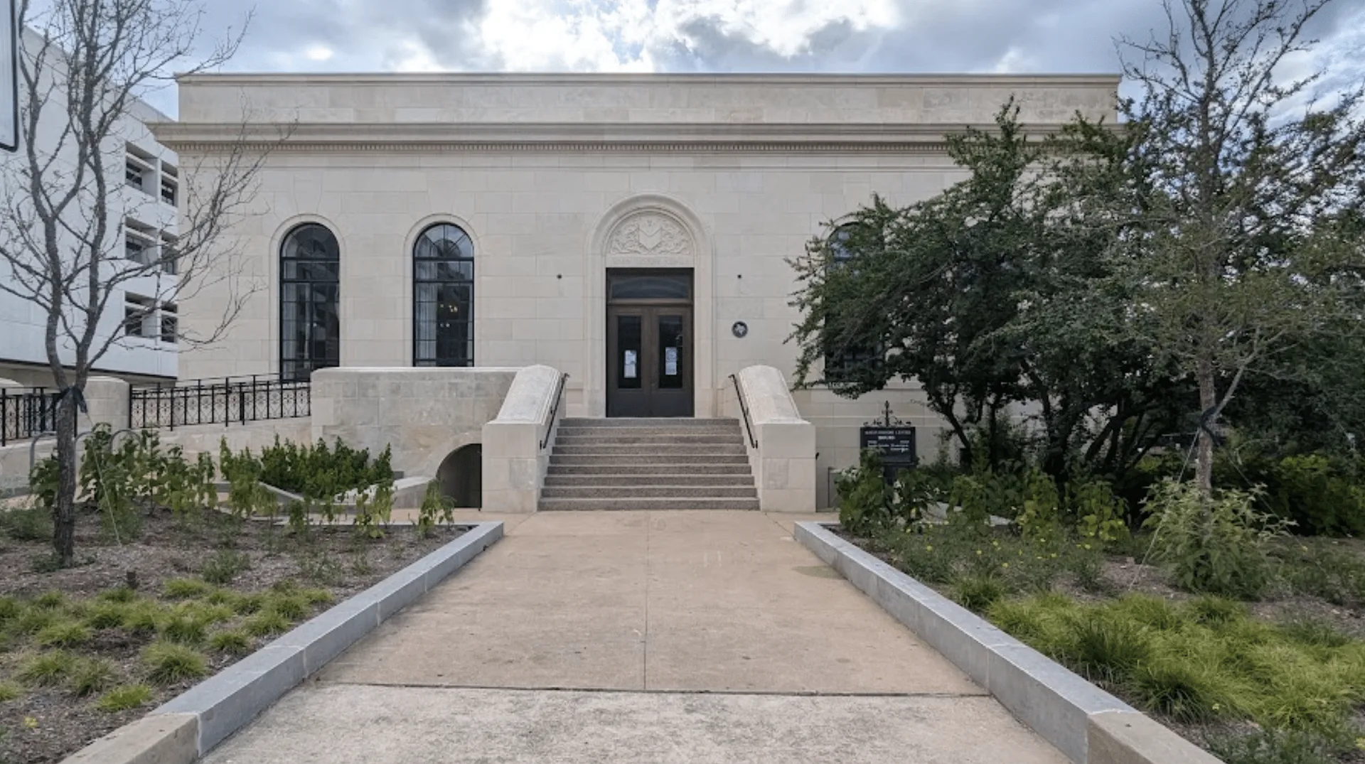 Grupo de personas distribuyendo cajas de alimentos frente a una iglesia con una gran multitud de fondo.