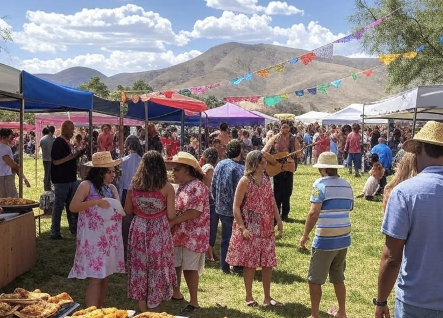Multitud de personas en un evento al aire libre con sombreros y vestimenta colorida en un mercado.