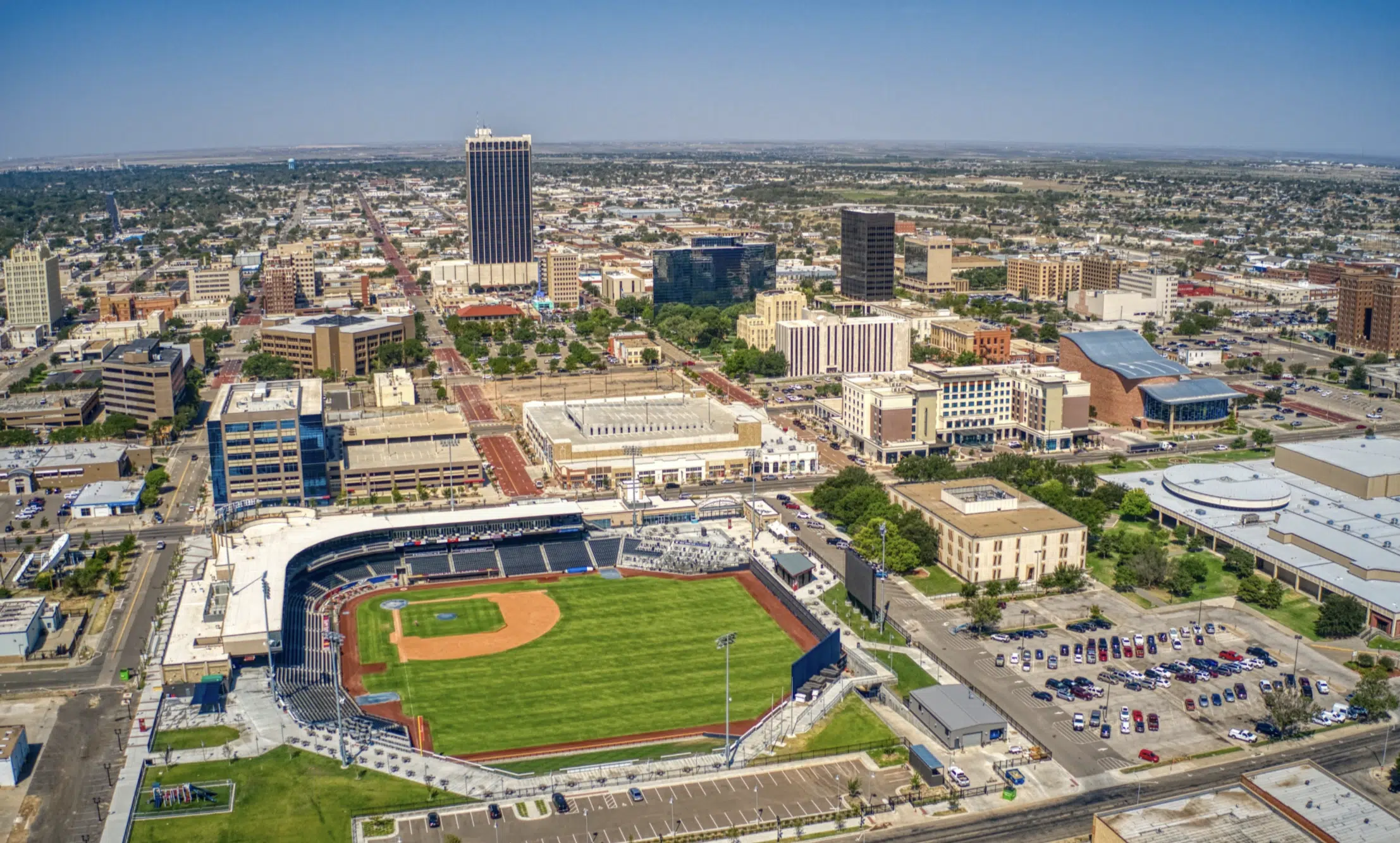 Vista aérea de un estadio de béisbol rodeado de edificios en una ciudad.