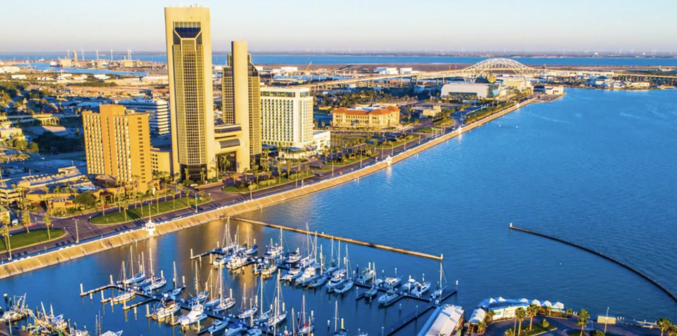 Vista aérea del puerto de Corpus Christi con edificios y embarcaciones en el agua.